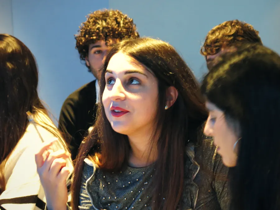 Una giovane partecipante interviene durante il workshop, con un compagno alle spalle.