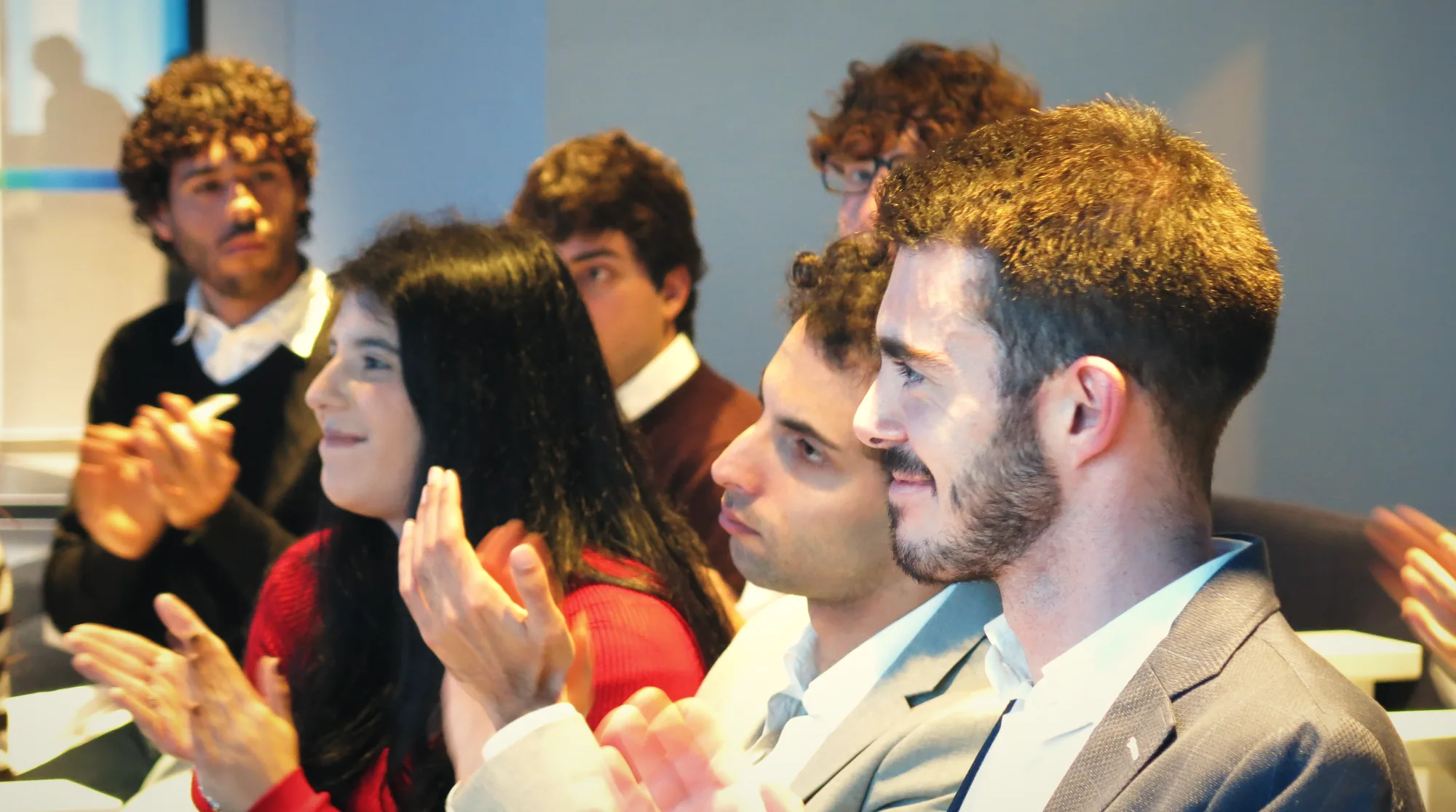 Giovani partecipanti applaudono un intervento durante il workshop a Roma.